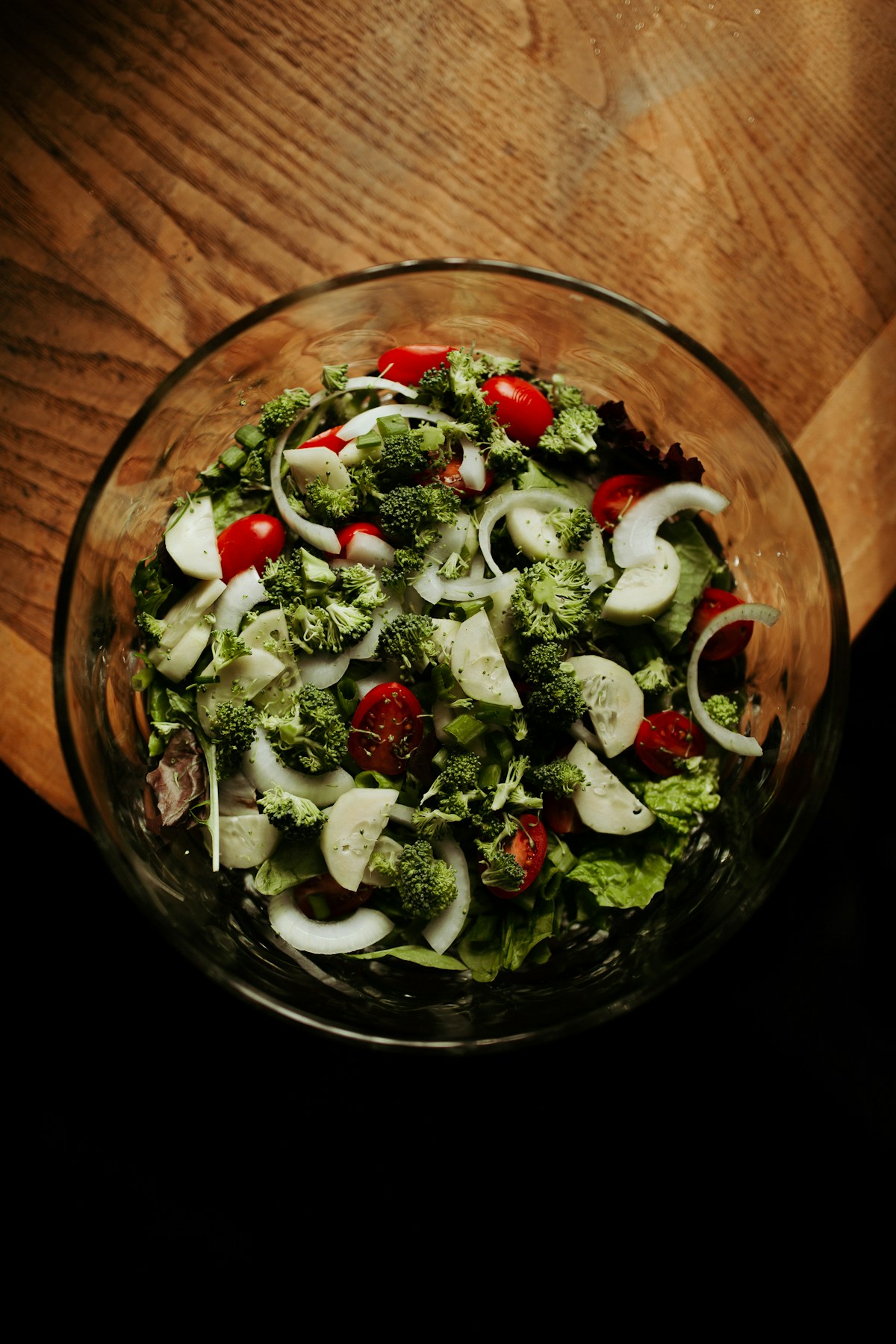 A bowl of fresh vegetables on a wooden table